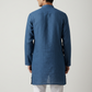 Man wearing a blue kurta against a plain background