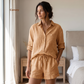Woman wearing a beige linen outfit in a bedroom setting