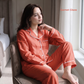 Woman in red pajamas sitting on a chair by a window, with 'Garnet Glaze' branding.