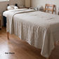A light oatmeal linen sheet draped over a massage table in a spa setting, with the text 'Oat Dune' in the bottom-left corner.